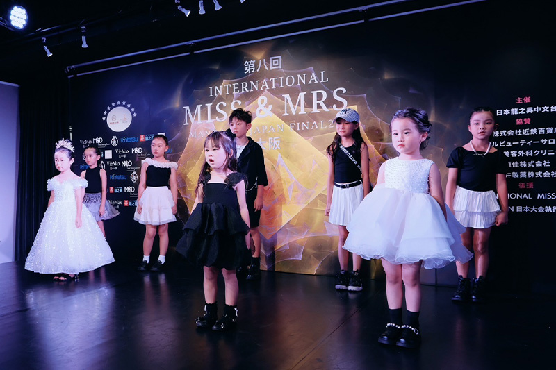 子どもたちが舞台でファッションショーに参加している様子
